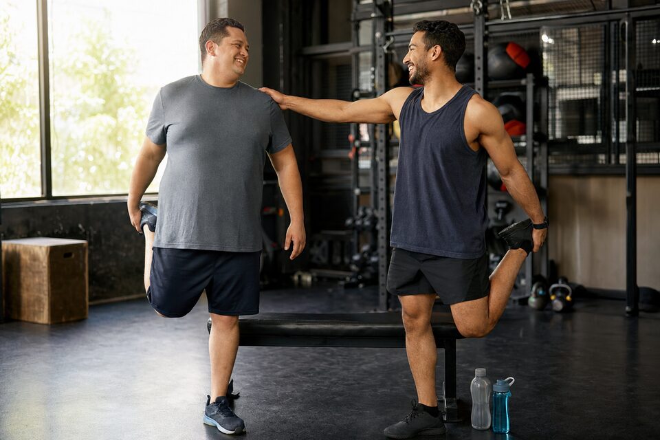 Two adults prepare to train together at a gym